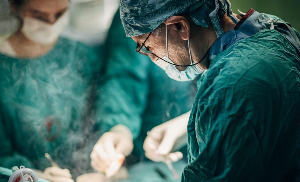 Group of surgeons performing surgery on a patient in a Serbian operating room. Surgeon is using electrical coagulator during the operation.