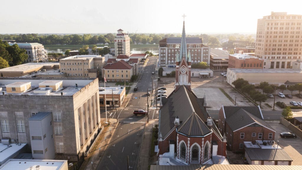 Monroe, Louisiana, 2024: Afternoon sunlight shines on the historic buildings and church in the skyline. 
