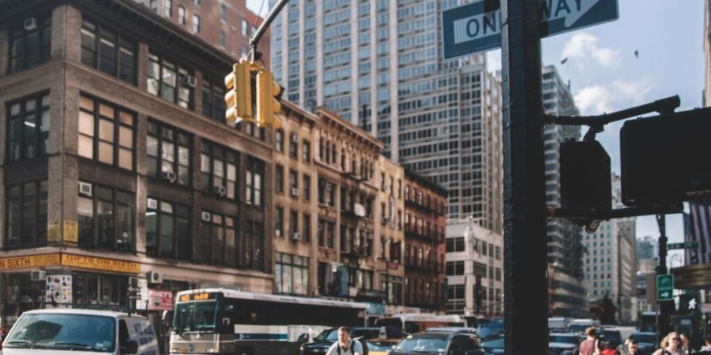 New York, USA - April 16, 2022: People walking on the street in Manhattan, cityscape can be seen in the background.