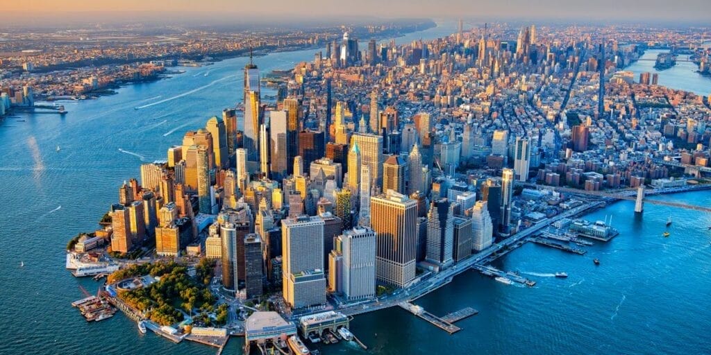 The skyline of Lower Manhattan's Financial District as well as the entire island of Manhattan, New York City, shot wide angle via helicopter from an altitude of about 1500 feet over New York Harbor.