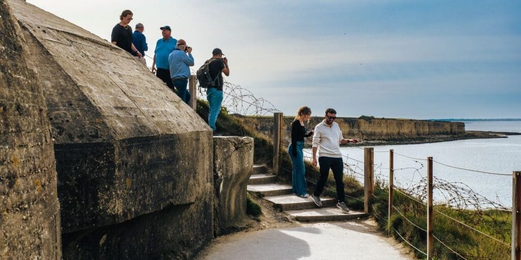 A tour group of people at Pointe du Hoc just west of Omaha Beach on the channel coast of Normandy, France. One of the most famous battle sites during the D-Day landings of 1944.