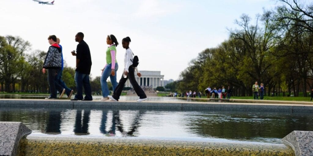 Washington DC, USA - April 9, 2008: Young people walk between the Lincoln Memorial (background) and the National World War II Memorial (out of view) on a visit to the capital.