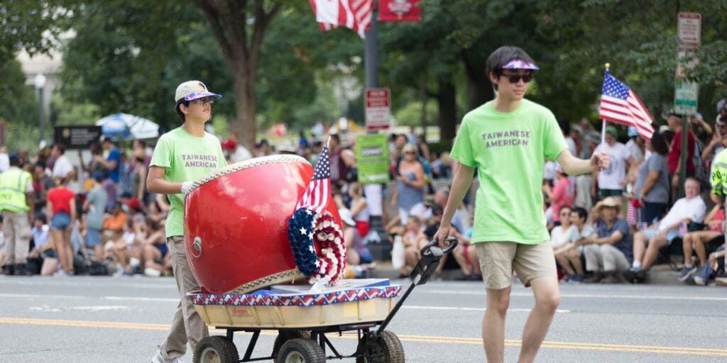 Washington, D.C., USA - July 4, 2018, The National Independence Day Parade, Taiwanese americans, waving american flags and playing a large drum, walking down constitution avenue